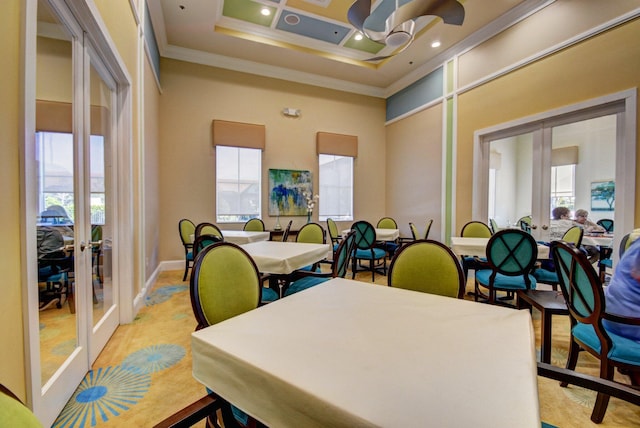 dining space with french doors, a towering ceiling, and crown molding