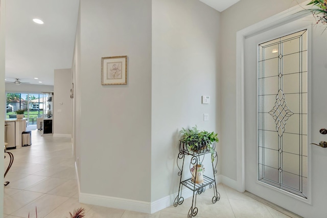 foyer entrance with light tile patterned floors and ceiling fan