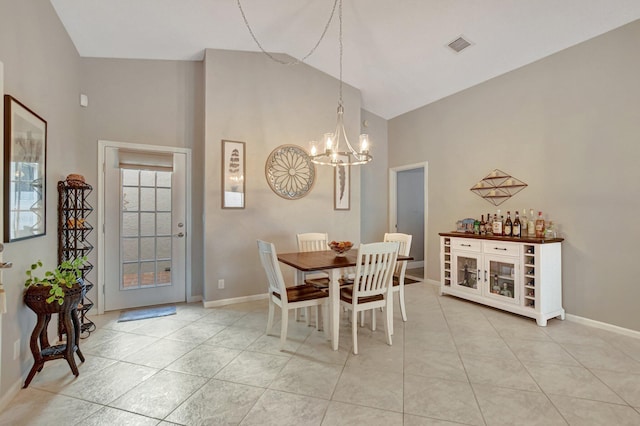 tiled dining area with high vaulted ceiling and an inviting chandelier