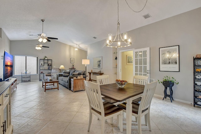 tiled dining room featuring ceiling fan with notable chandelier, vaulted ceiling, and a textured ceiling