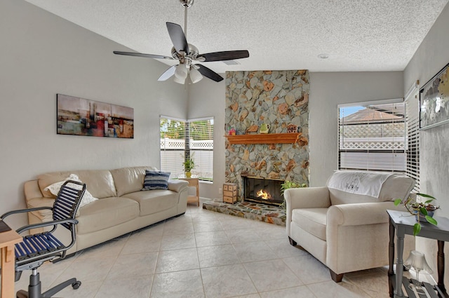 tiled living room featuring vaulted ceiling, ceiling fan, a textured ceiling, and a fireplace