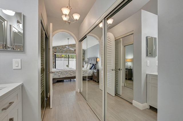 bathroom with vanity, hardwood / wood-style floors, and ceiling fan with notable chandelier