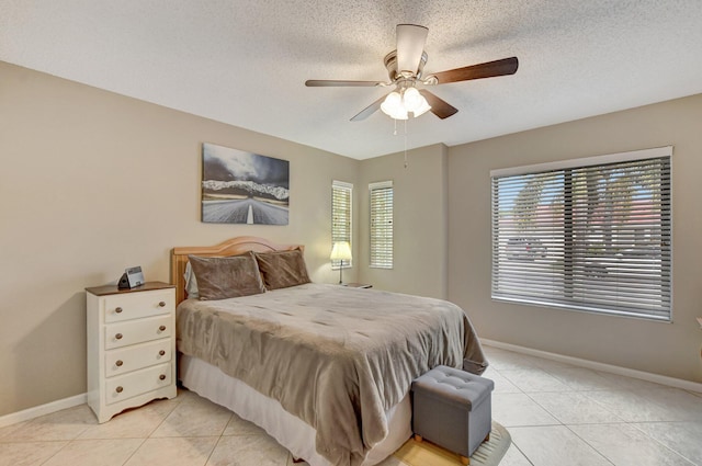 tiled bedroom featuring a textured ceiling and ceiling fan