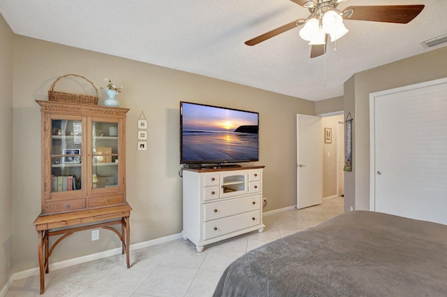 tiled bedroom with a textured ceiling and ceiling fan