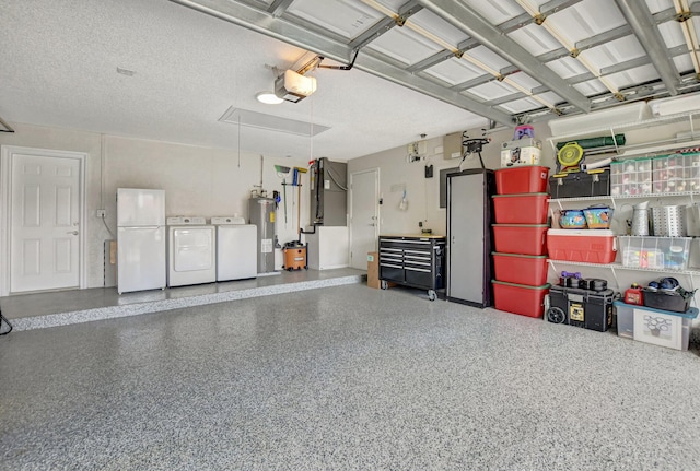 garage with white refrigerator, a garage door opener, washing machine and clothes dryer, and water heater