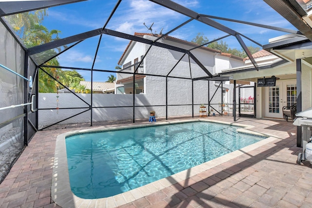 view of swimming pool featuring a patio area and glass enclosure