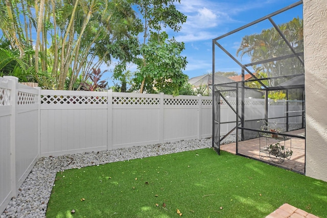 view of yard featuring a patio and glass enclosure