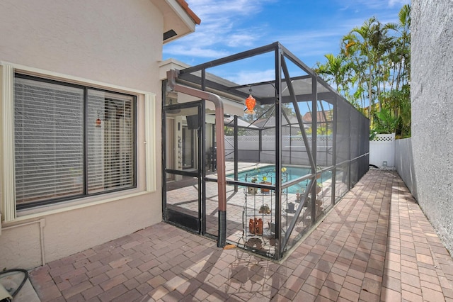 view of pool featuring glass enclosure and a patio area