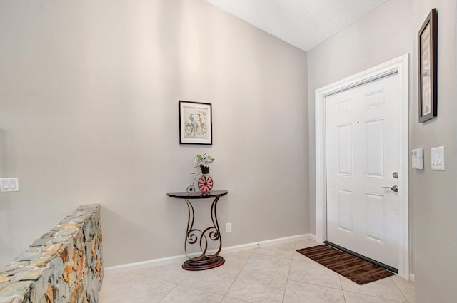 foyer entrance featuring a textured ceiling and light tile patterned floors