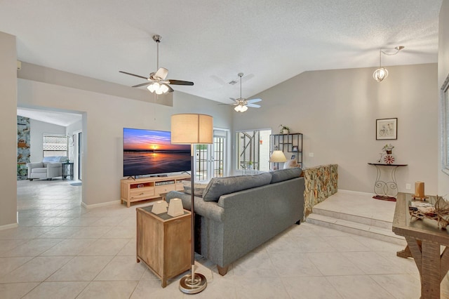 living room featuring a wealth of natural light, lofted ceiling, light tile patterned floors, and a textured ceiling