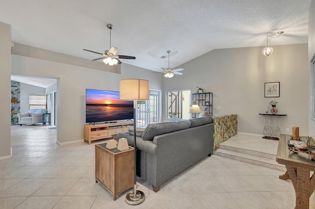 tiled living room with ceiling fan, vaulted ceiling, and a textured ceiling