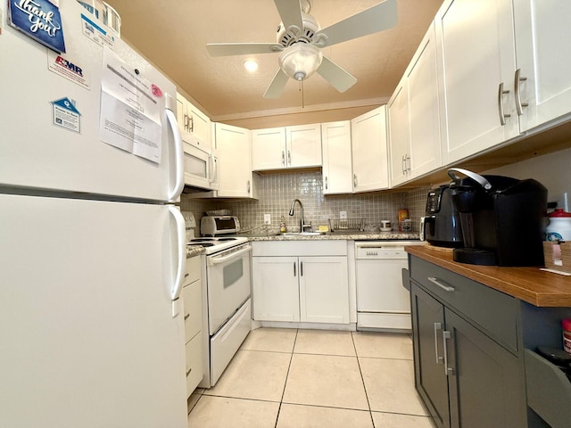 kitchen with white cabinetry, light tile patterned floors, white appliances, and decorative backsplash