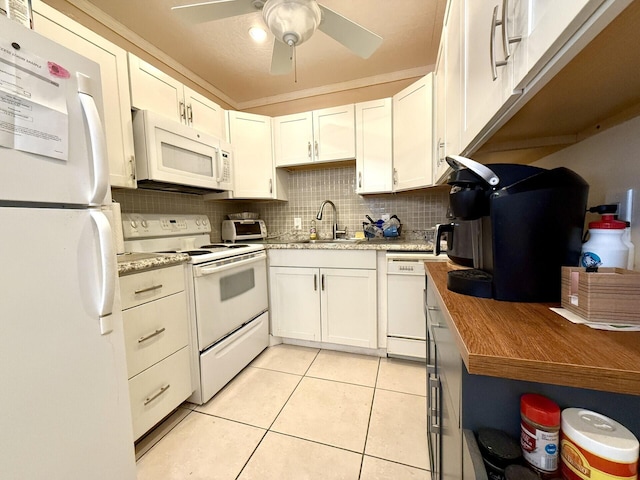 kitchen with sink, backsplash, white cabinets, light tile patterned floors, and white appliances