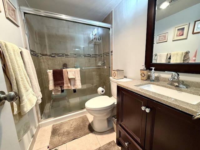 bathroom with vanity, a shower with shower door, tile patterned floors, and toilet