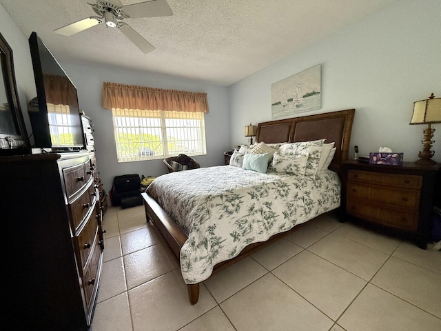 tiled bedroom with ceiling fan and a textured ceiling