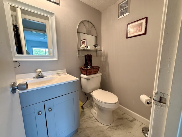 bathroom featuring vanity, a textured ceiling, and toilet