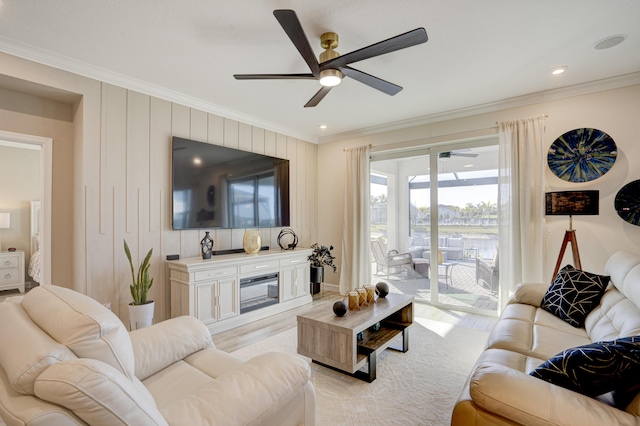 living room featuring light carpet, crown molding, a fireplace, and ceiling fan