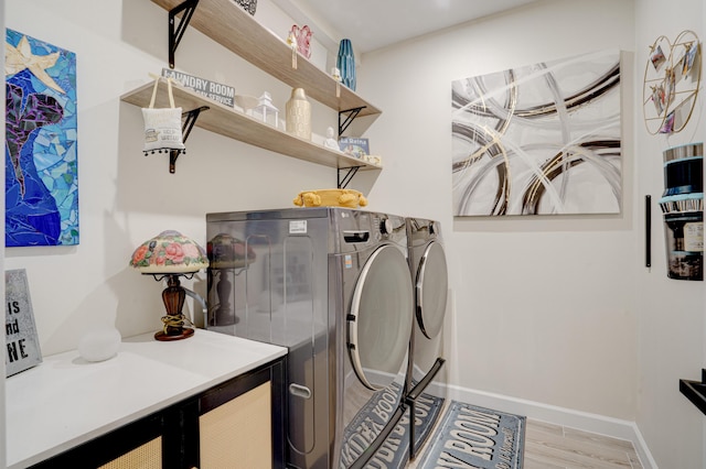 laundry area with independent washer and dryer and light wood-type flooring