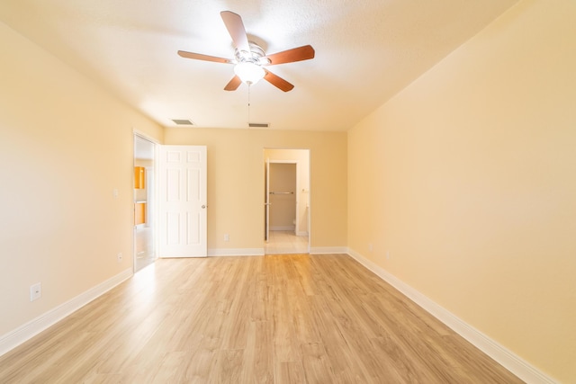 unfurnished room with ceiling fan and light wood-type flooring