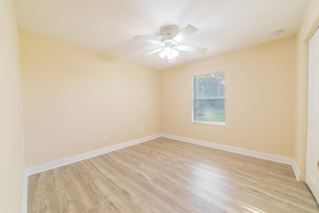 empty room with ceiling fan and light hardwood / wood-style flooring