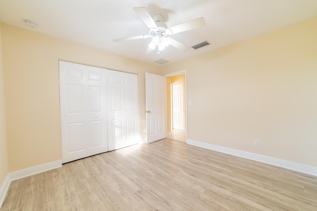 unfurnished bedroom with ceiling fan, a closet, and light hardwood / wood-style flooring