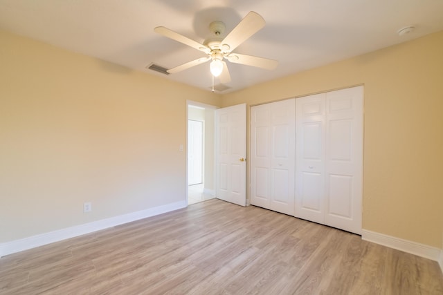 unfurnished bedroom with light hardwood / wood-style flooring, ceiling fan, and a closet