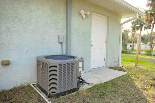 property entrance featuring cooling unit and a lawn