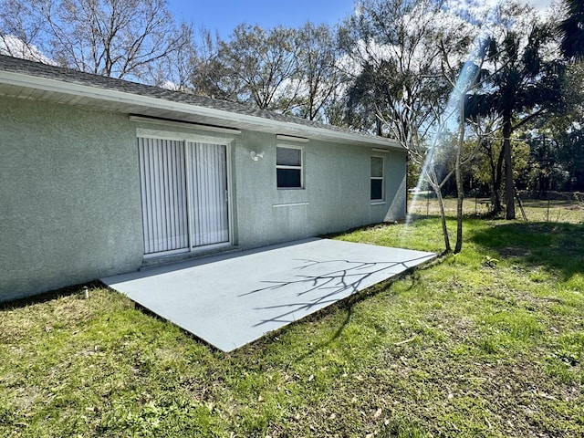 back of property featuring a yard and a patio area