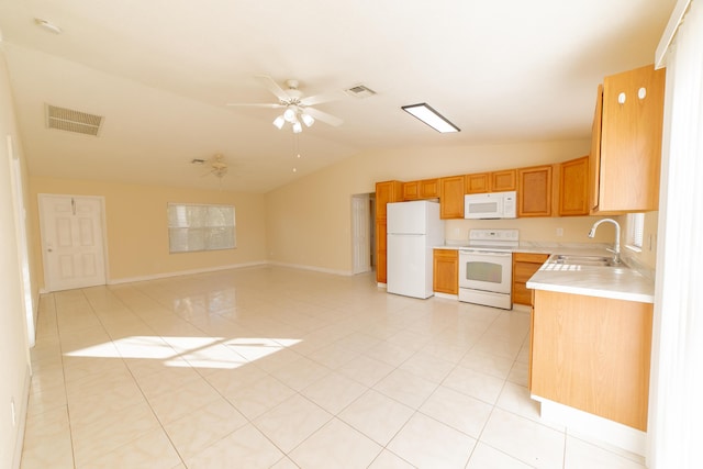 kitchen featuring lofted ceiling, sink, light tile patterned floors, and white appliances