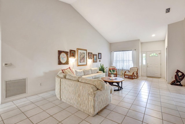 living area featuring high vaulted ceiling, visible vents, and light tile patterned floors