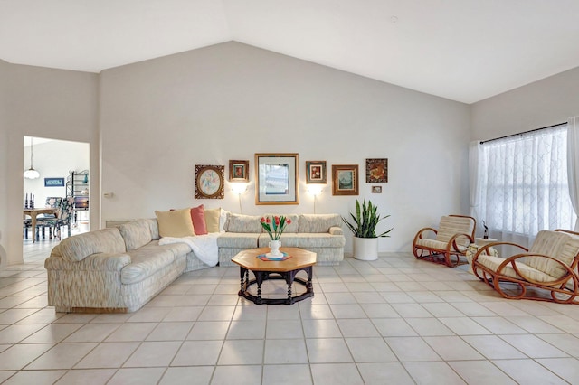 living room with high vaulted ceiling and light tile patterned floors