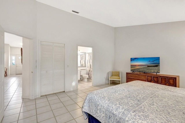 bedroom featuring light tile patterned floors, high vaulted ceiling, a closet, and visible vents