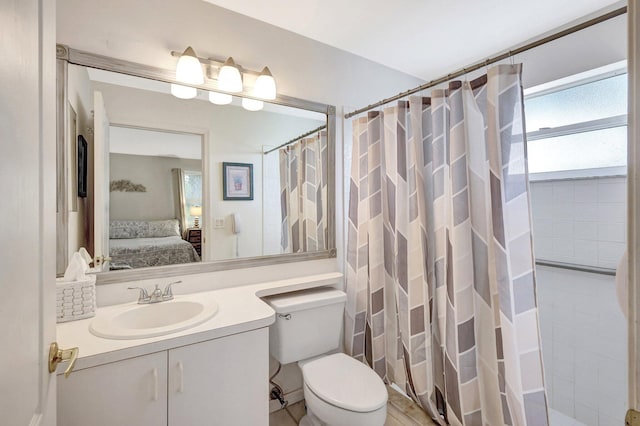 ensuite bathroom with toilet, a shower with curtain, connected bathroom, and vanity