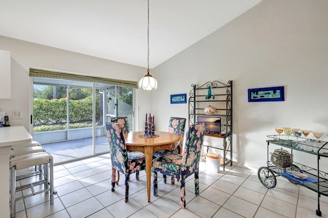 dining space featuring lofted ceiling and light tile patterned floors