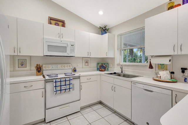 kitchen featuring white appliances, white cabinets, vaulted ceiling, light countertops, and a sink