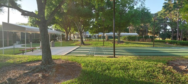 view of home's community featuring a yard and shuffleboard