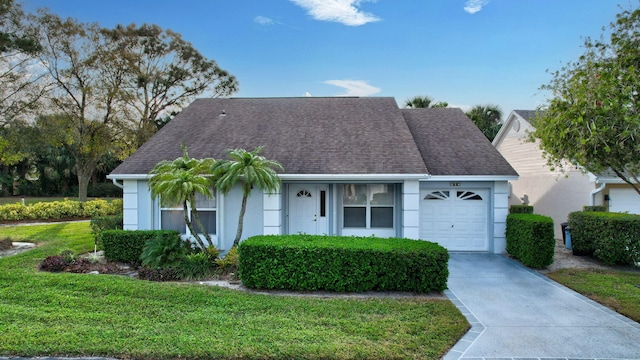 view of front facade featuring stucco siding, a shingled roof, concrete driveway, an attached garage, and a front yard