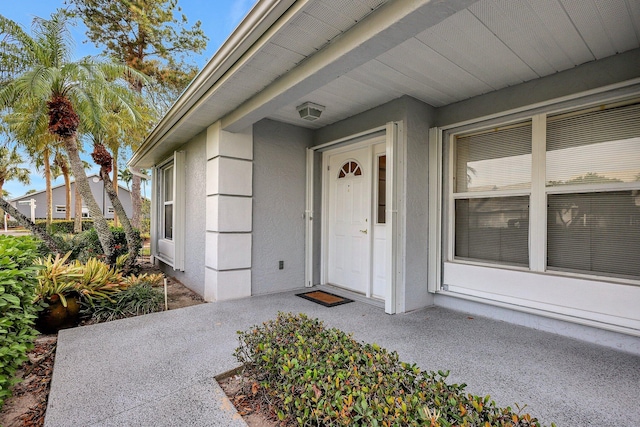 doorway to property featuring stucco siding