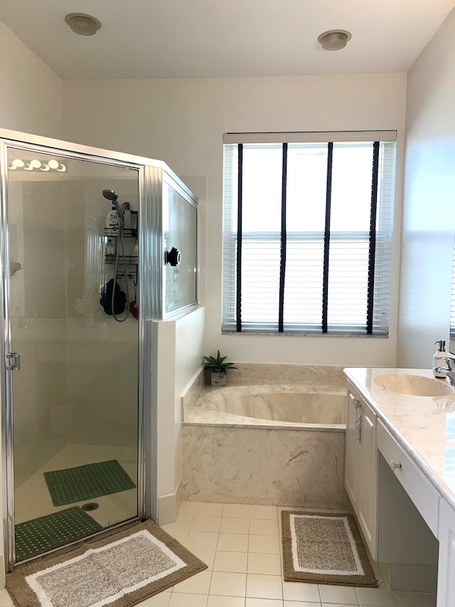 bathroom with tile patterned flooring, vanity, and separate shower and tub