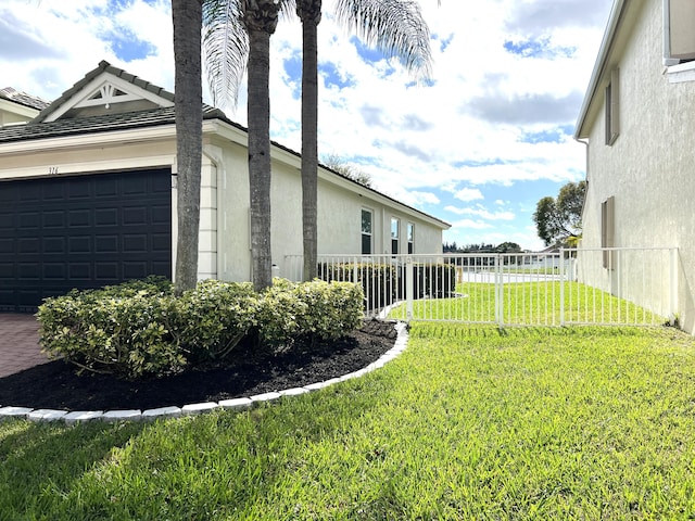 view of side of home featuring a garage and a lawn