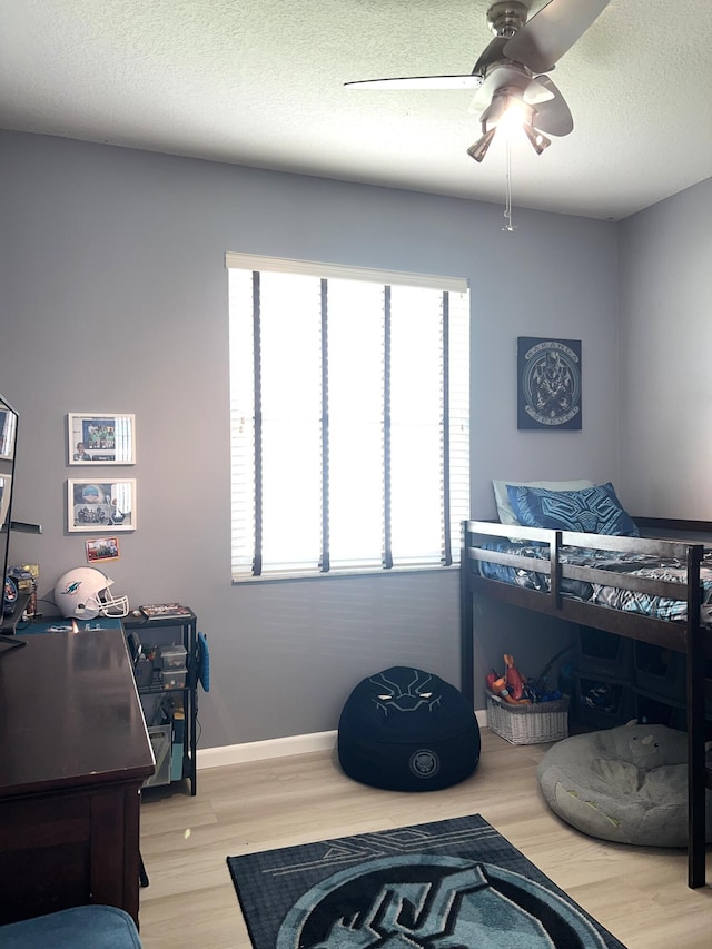 bedroom with hardwood / wood-style flooring, a textured ceiling, and ceiling fan