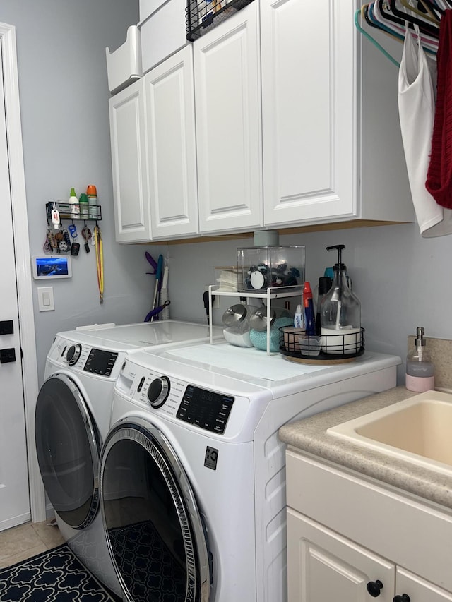 clothes washing area featuring light tile patterned flooring, cabinets, and separate washer and dryer