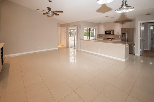 kitchen featuring appliances with stainless steel finishes, light brown cabinets, ceiling fan, and light tile patterned floors