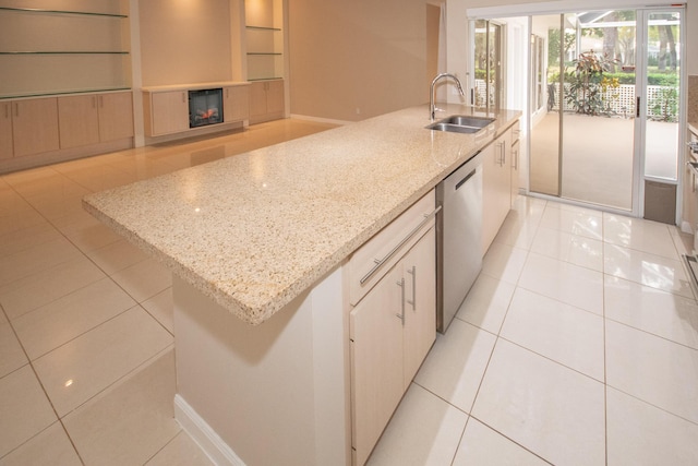 kitchen with dishwasher, an island with sink, sink, white cabinets, and light stone countertops