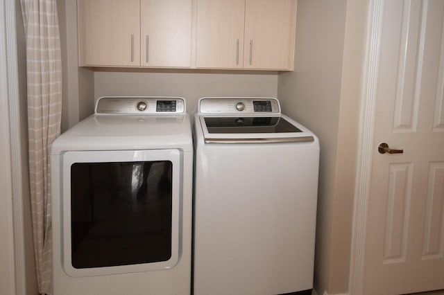 laundry room with cabinets and washing machine and dryer