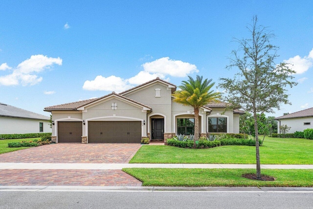 mediterranean / spanish home featuring a garage and a front lawn