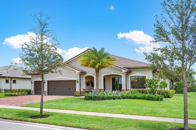 mediterranean / spanish home featuring a garage and a front lawn