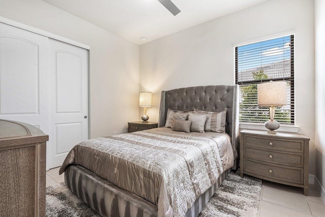 tiled bedroom featuring ceiling fan and a closet