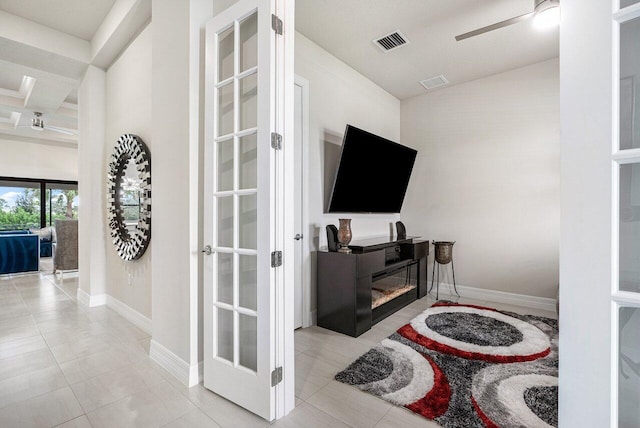 tiled living room featuring beamed ceiling, ceiling fan, coffered ceiling, and french doors