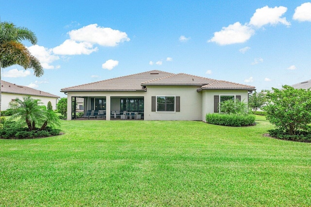 rear view of property featuring a yard